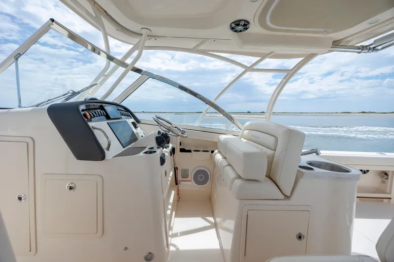 Slide: The Image of 2020 Grady-White Freedom 307 boat interior with helm and seating, overlooking the ocean. - 16
