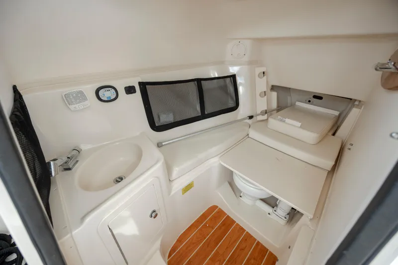 Slide: The Image of 2020 Grady-White Freedom 307 boat interior with sink, toilet, and storage. - 21