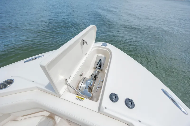 Slide: The Image of 2020 Grady-White Freedom 307 boat anchor compartment open on calm water. - 22