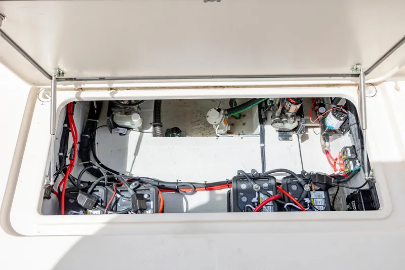 Slide: The Image of 2020 Grady-White Freedom 307 boat battery compartment with wiring and components. - 24