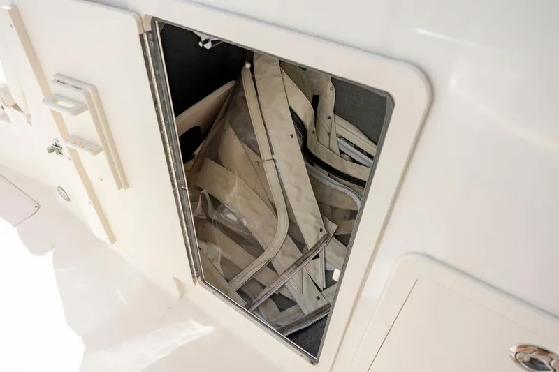 Slide: The Image of Storage compartment on 2020 Grady-White Freedom 307 boat, containing folded canvas. - 26