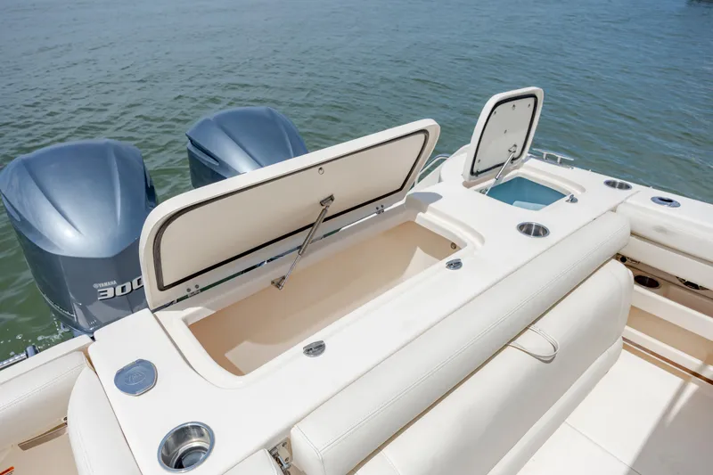 Slide: The Image of 2020 Grady-White Freedom 307 boat with open storage compartments and twin engines on water. - 9