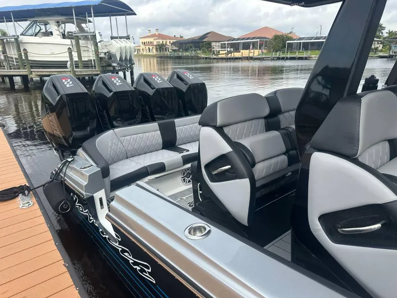 Slide: The Image of 2025 Nor-Tech 400 Supersport boat with luxurious seating and powerful engines docked by the water. - 3