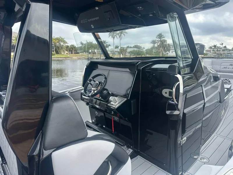 Slide: The Image of 2025 Nor-Tech 400 Supersport boat interior with sleek black dashboard and modern steering wheel. - 9
