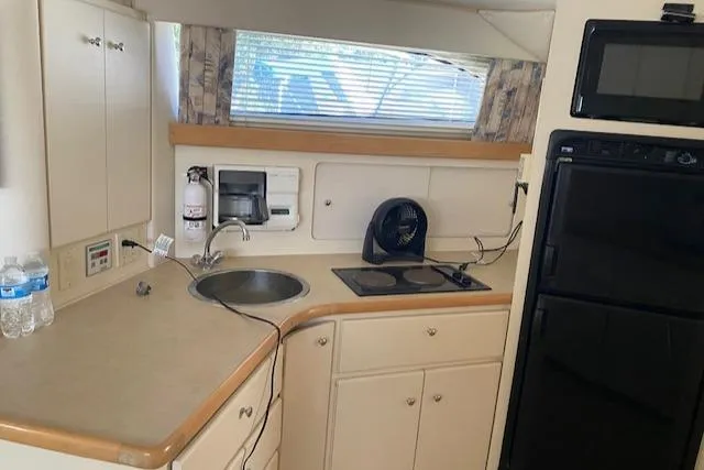 Slide: The Image of 1998 Carver 380 Santego yacht kitchen with sink, stove, and refrigerator. - 5