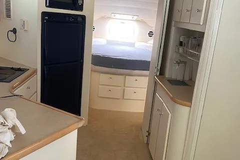 Slide: The Image of Interior of 1998 Carver 380 Santego yacht, featuring kitchen and cozy sleeping area. - 11