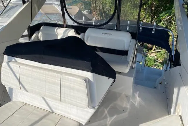 Slide: The Image of 1998 Carver 380 Santego yacht interior with white seating and black cover. - 16