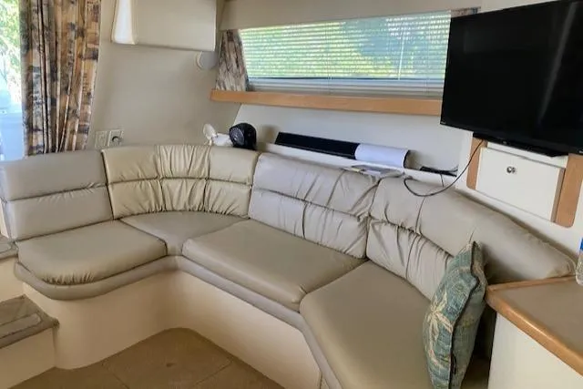 Slide: The Image of Interior of 1998 Carver 380 Santego yacht with beige leather seating and mounted TV. - 6