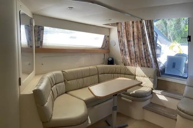 Slide: The Image of Interior of 1998 Carver 380 Santego yacht with beige seating and dining table. - 7