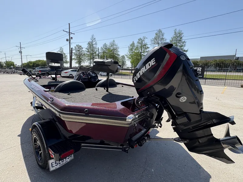 Slide: The Image of 1999 Champion MEAN 16 boat with Evinrude motor, parked outdoors. - 4