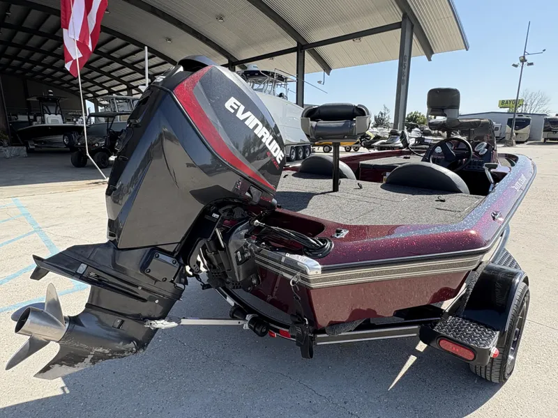 Slide: The Image of 1999 Champion MEAN 16 boat with Evinrude motor, parked under a canopy. - 5