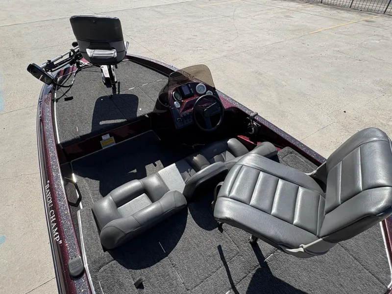 Slide: The Image of 1999 Champion MEAN 16 boat interior with gray seats and steering console. - 6