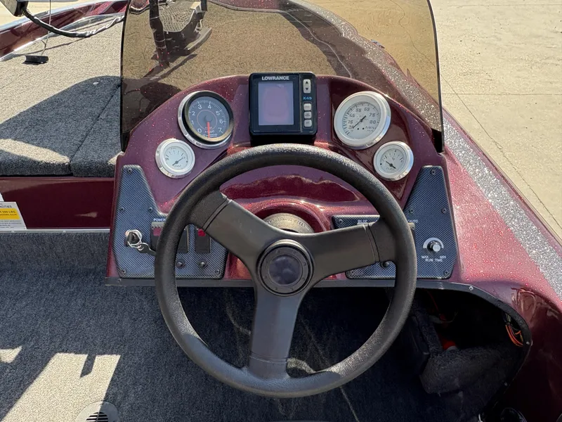 Slide: The Image of 1999 Champion MEAN 16 boat dashboard with steering wheel and gauges. - 9
