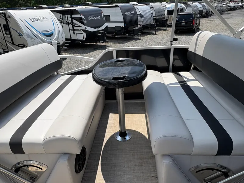 Slide: The Image of 2020 G3 SunCatcher boat interior with seating and table, surrounded by parked RVs. - 14