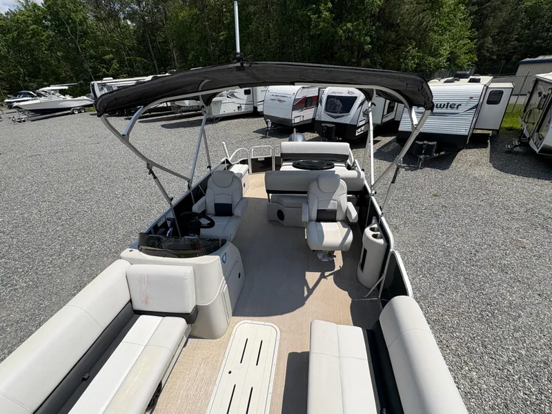 Slide: The Image of 2020 G3 SunCatcher pontoon boat with canopy, parked on gravel lot, surrounded by RVs. - 25