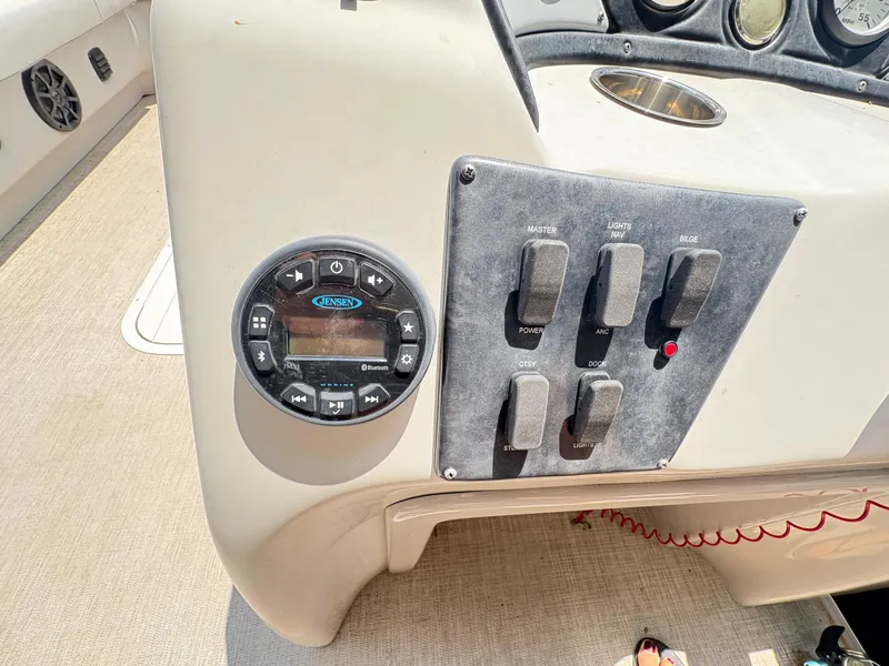 Slide: The Image of Control panel of a 2020 G3 SunCatcher boat with switches and a Jensen audio system. - 28