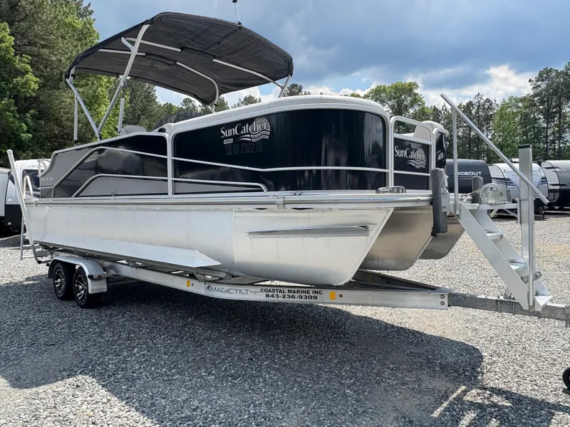 Slide: The Image of 2020 G3 SunCatcher pontoon boat on trailer, parked outdoors under cloudy sky. - 5