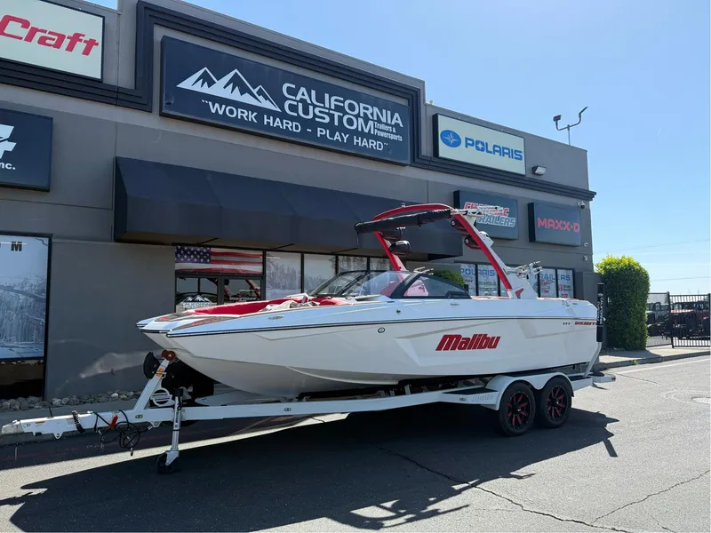 The Image of 2023 Malibu Wakesetter 23 MXZ boat on trailer outside California Custom store. - 0