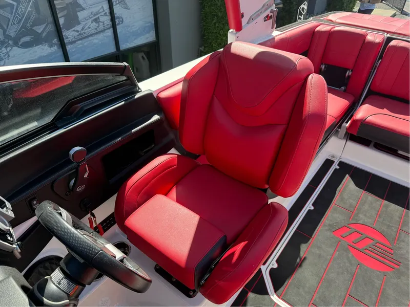 Slide: The Image of 2023 Malibu Wakesetter 23 MXZ boat with red captain's seat and steering wheel. - 11