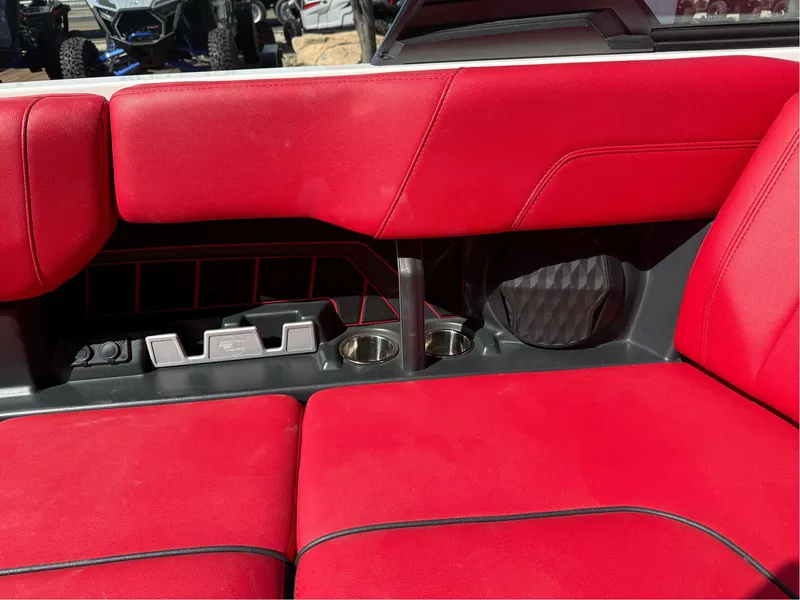 Slide: The Image of Red interior seating of 2023 Malibu Wakesetter 23 MXZ with cup holders and speaker. - 20
