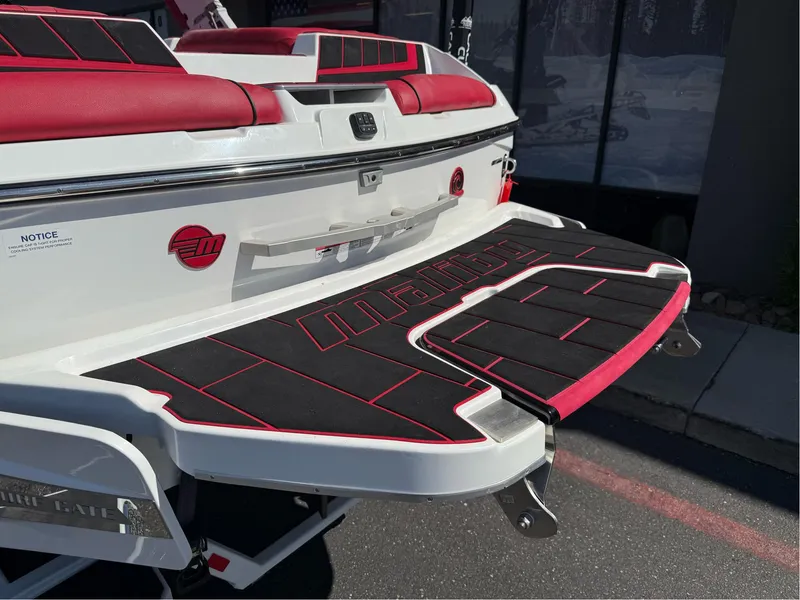 Slide: The Image of 2023 Malibu Wakesetter 23 MXZ boat with red and black detailing on the swim platform. - 33