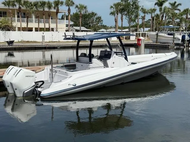 The Image of 2021 Airship 340 RIB boat docked in a marina with palm trees. - 0