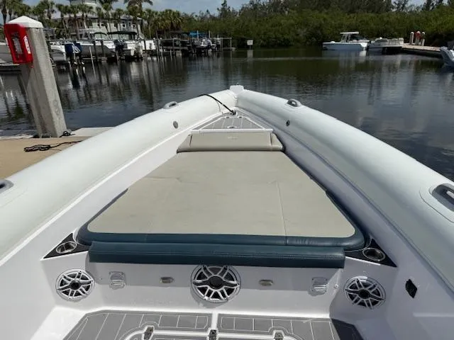 Slide: The Image of 2021 Airship 340 RIB boat docked, featuring spacious deck and seating area. - 12