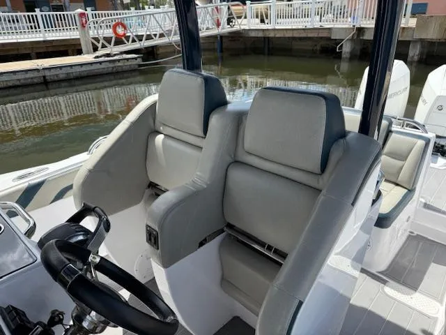 Slide: The Image of 2021 Airship 340 RIB boat interior with dual seats and steering wheel, dockside view. - 9
