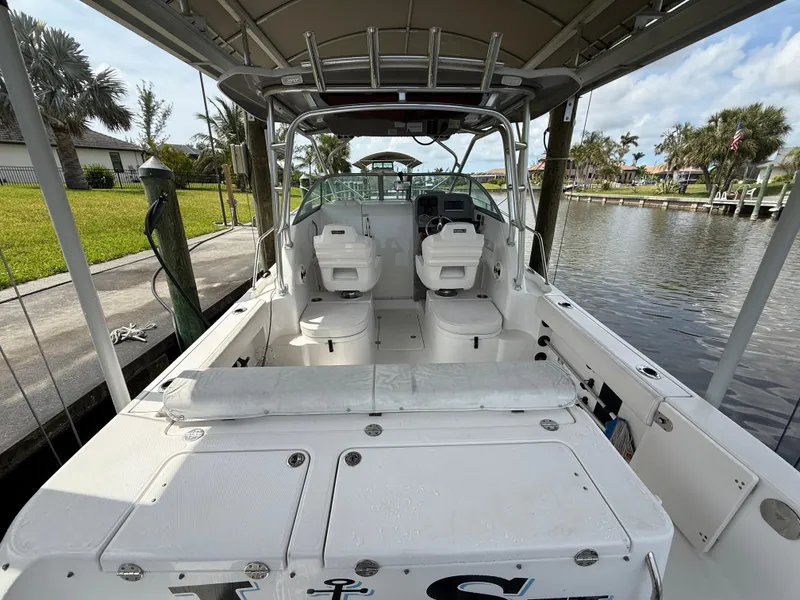 Slide: The Image of 2013 Robalo R245 Walkaround boat docked, featuring spacious cockpit and dual seating. - 10