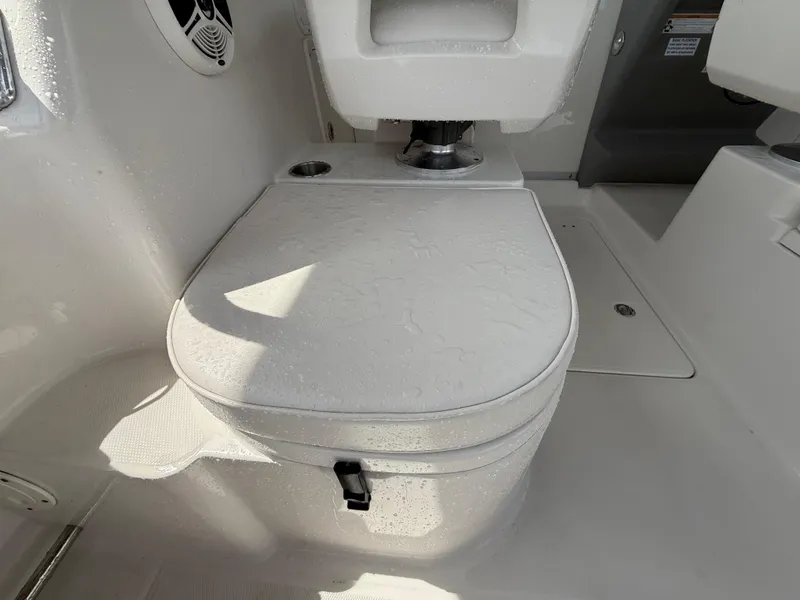 Slide: The Image of 2013 Robalo R245 Walkaround boat interior with cushioned seating and storage compartment. - 16