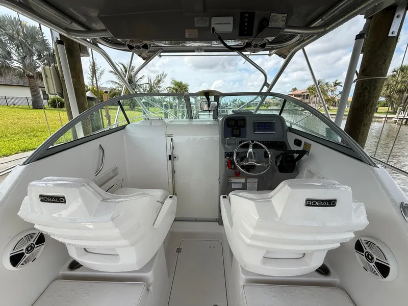 Slide: The Image of 2013 Robalo R245 Walkaround boat interior with dual seats and steering console. - 18