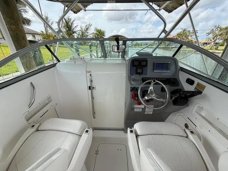 Slide: The Image of 2013 Robalo R245 Walkaround boat cockpit with dual seats and steering console. - 19