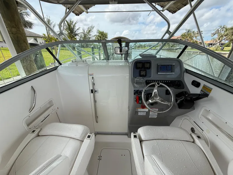 Slide: The Image of 2013 Robalo R245 Walkaround boat interior with steering wheel and seating. - 20