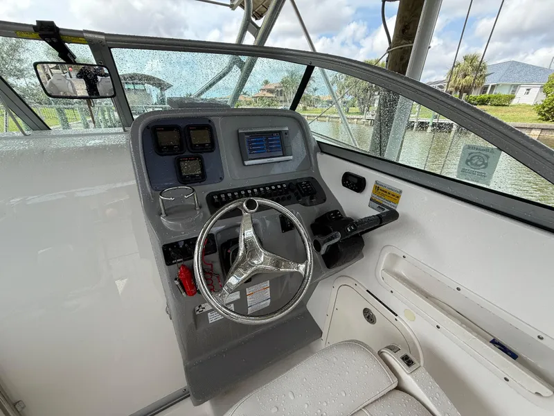 Slide: The Image of 2013 Robalo R245 Walkaround boat cockpit with steering wheel and control panel. - 21