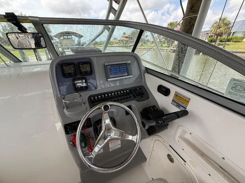 Slide: The Image of 2013 Robalo R245 Walkaround boat helm with steering wheel and navigation controls. - 24