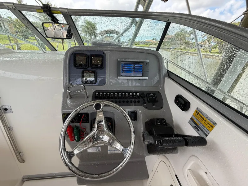 Slide: The Image of 2013 Robalo R245 Walkaround boat dashboard with steering wheel and control panel. - 25