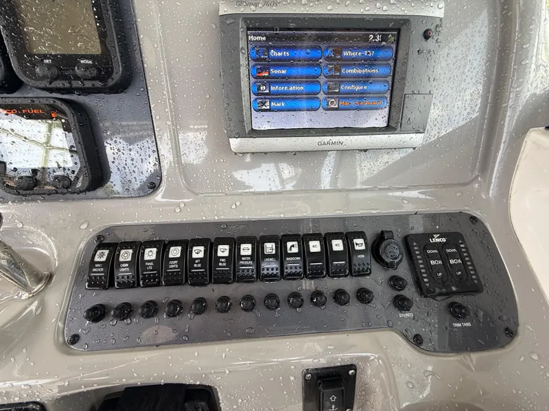 Slide: The Image of Control panel of a 2013 Robalo R245 Walkaround boat with electronic displays and switches. - 26