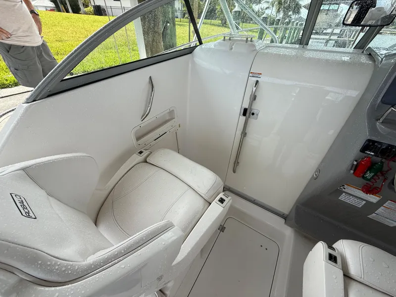 Slide: The Image of 2013 Robalo R245 Walkaround boat interior with white seating and cabin door. - 31