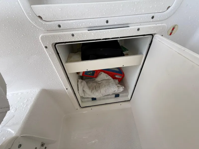 Slide: The Image of 2013 Robalo R245 Walkaround boat storage compartment with towels and supplies. - 33