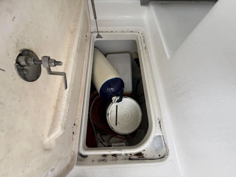Slide: The Image of Storage compartment on a 2013 Robalo R245 Walkaround boat with various equipment inside. - 35