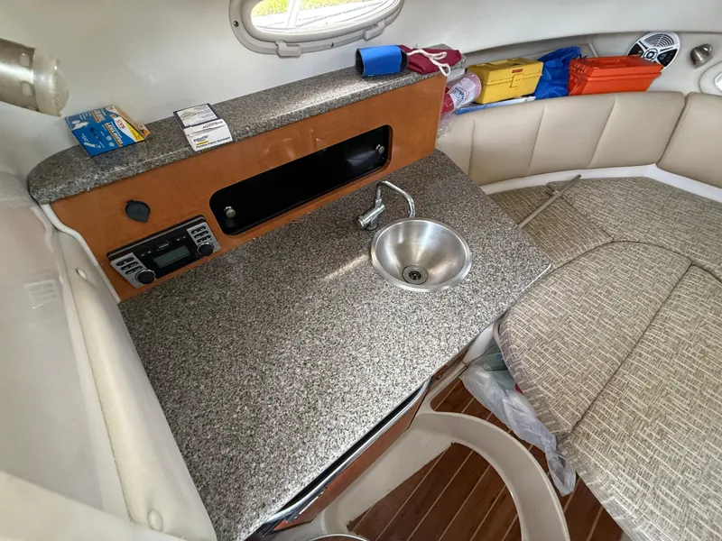 Slide: The Image of 2013 Robalo R245 Walkaround cabin with kitchenette, sink, and seating area. - 38