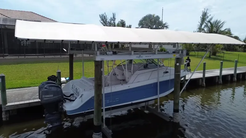 Slide: The Image of 2013 Robalo R245 Walkaround boat docked under canopy on a lift. - 4