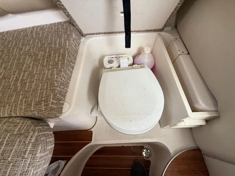 Slide: The Image of 2013 Robalo R245 Walkaround boat interior with toilet and seating area. - 43