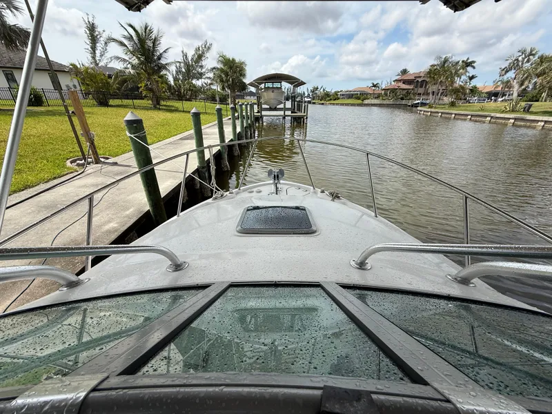 Slide: The Image of 2013 Robalo R245 Walkaround boat docked by a scenic canal. - 44