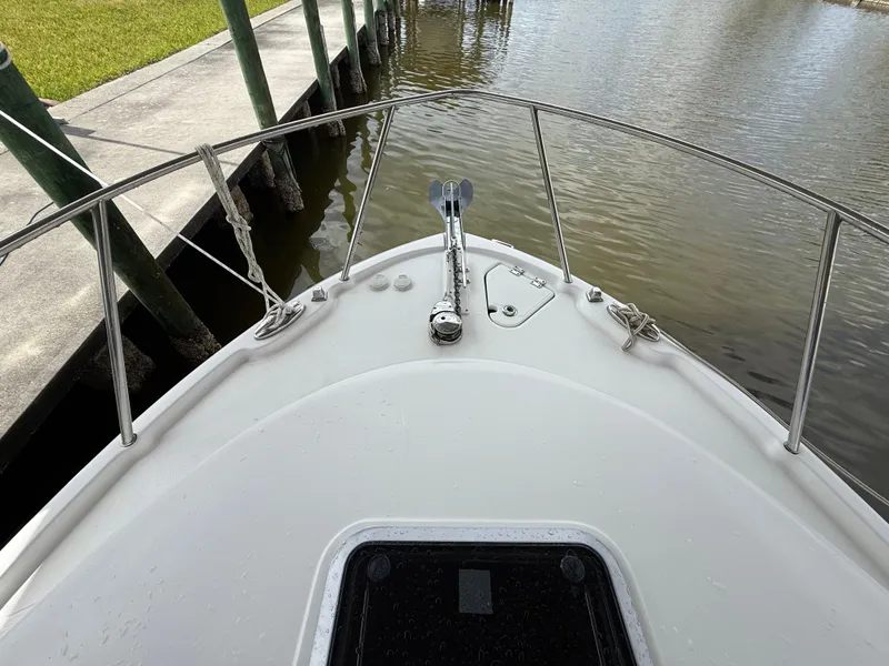 Slide: The Image of Bow of 2013 Robalo R245 Walkaround boat docked by a pier. - 46