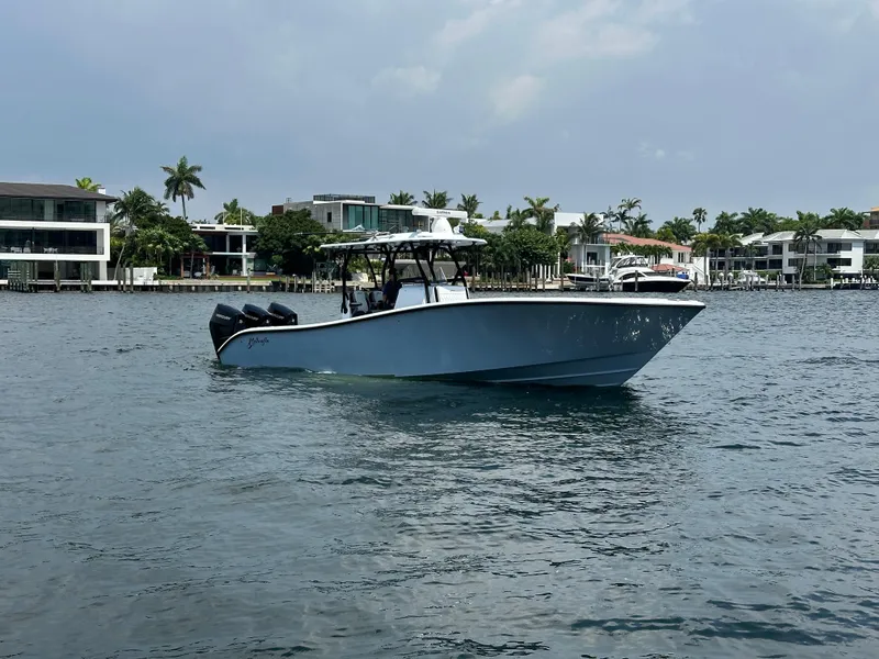 Slide: The Image of 2024 Yellowfin 34 Offshore boat cruising near waterfront homes. - 1