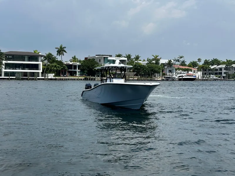 Slide: The Image of 2024 Yellowfin 34 Offshore boat cruising near waterfront homes. - 5