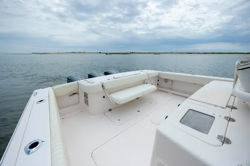 Slide: The Image of 2011 Grady-White Canyon 366 boat on calm water, showcasing spacious deck and seating. - 13