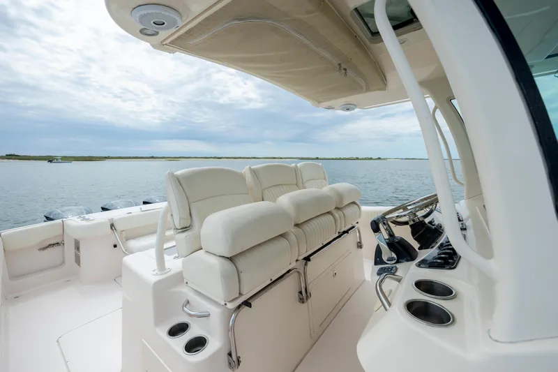 Slide: The Image of 2011 Grady-White Canyon 366 boat interior with plush seating and steering console on open water. - 17