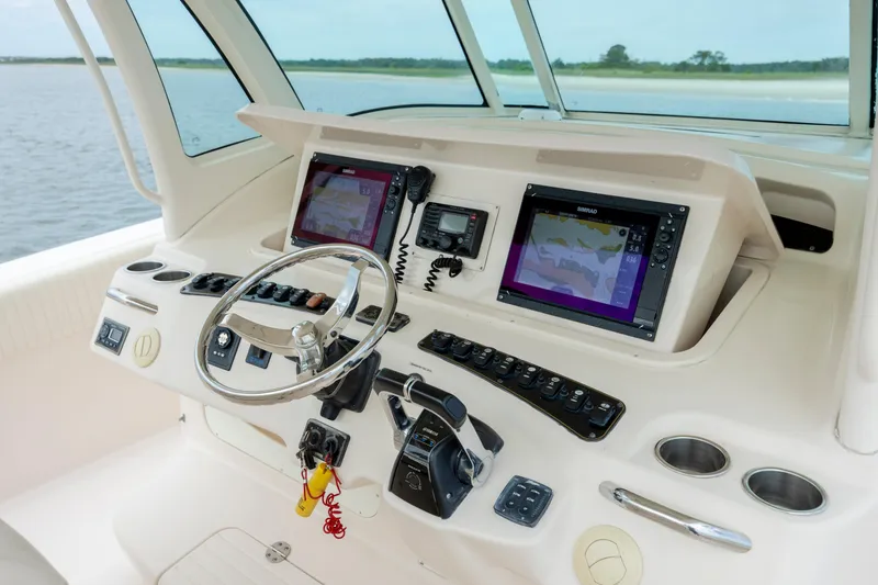 Slide: The Image of 2011 Grady-White Canyon 366 boat dashboard with navigation screens and controls. - 20